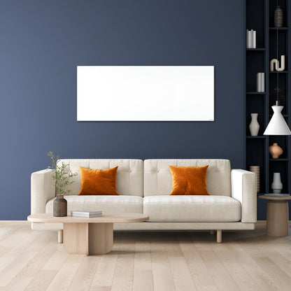 Wit infraroodpaneel gemonteerd aan een donkerblauwe wand boven een beige sofa in een moderne woonkamer
