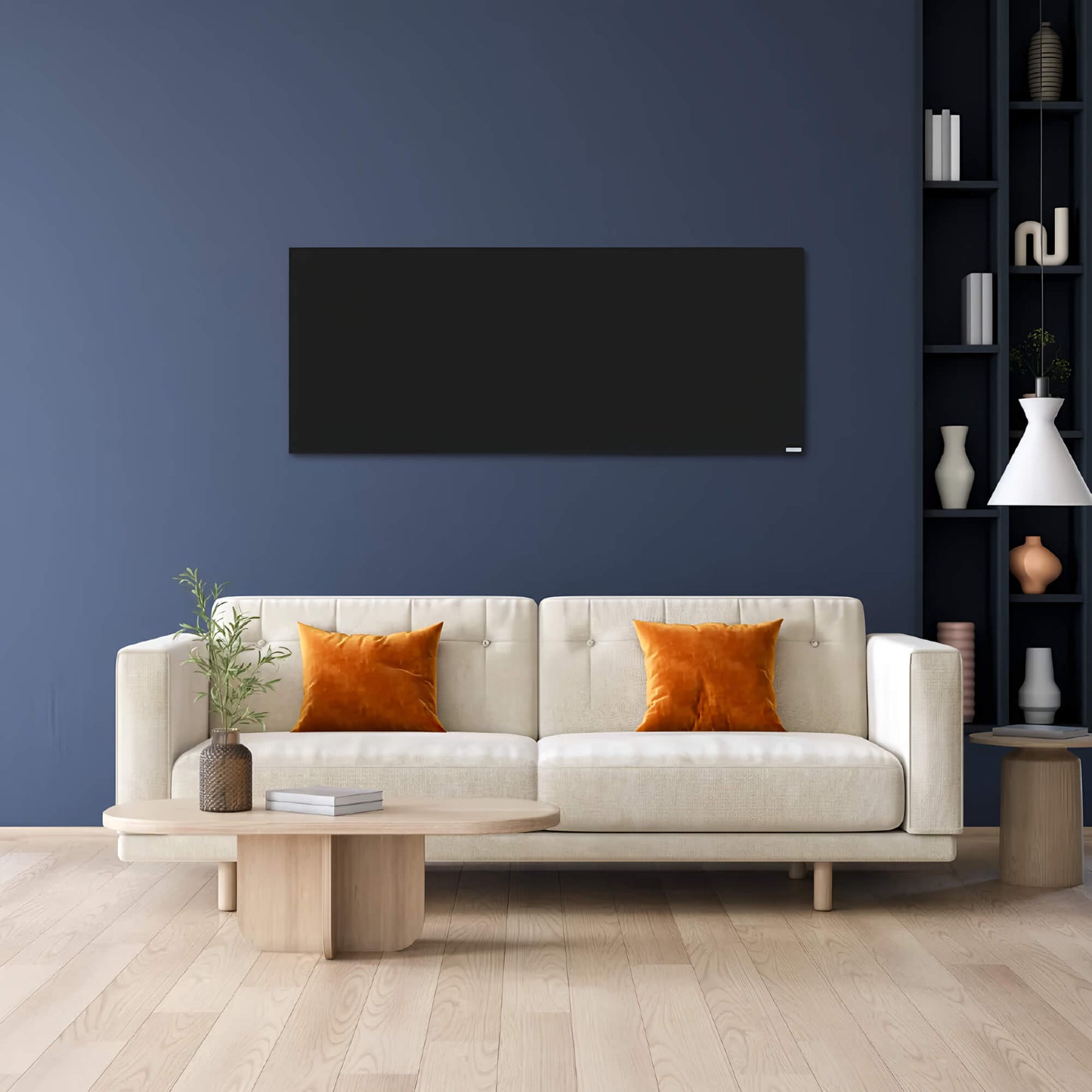Zwart infraroodpaneel gemonteerd aan een donkerblauwe wand boven een beige sofa in een moderne woonkamer 