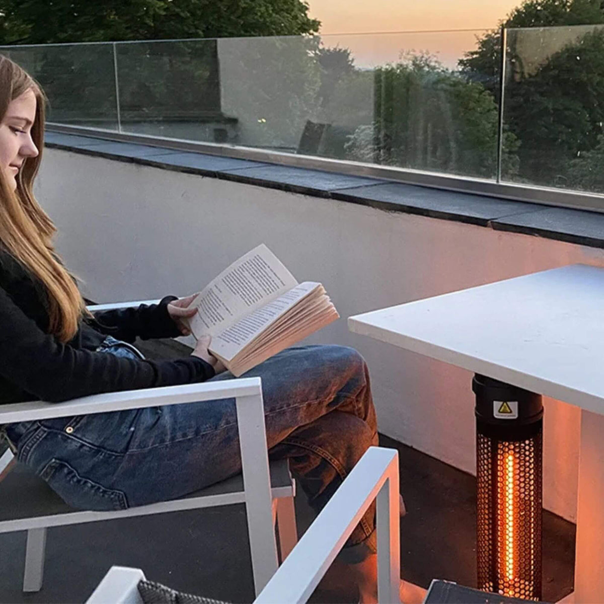 Herschel HAVANA 800 W, zwarte  terrasverwarmer naast een zitplaats op het terras