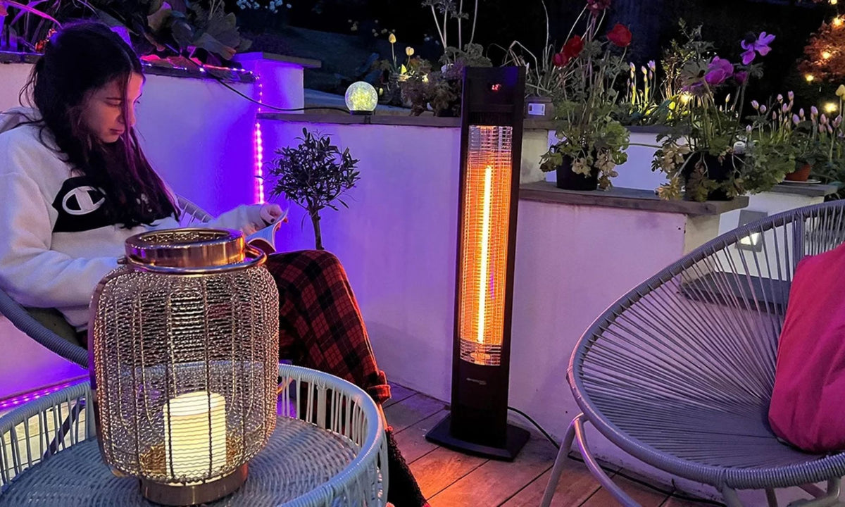 Herschel MALIBU 2000 W, zwarte infrarood terrasverwarmer naast een persoon op een terras.
