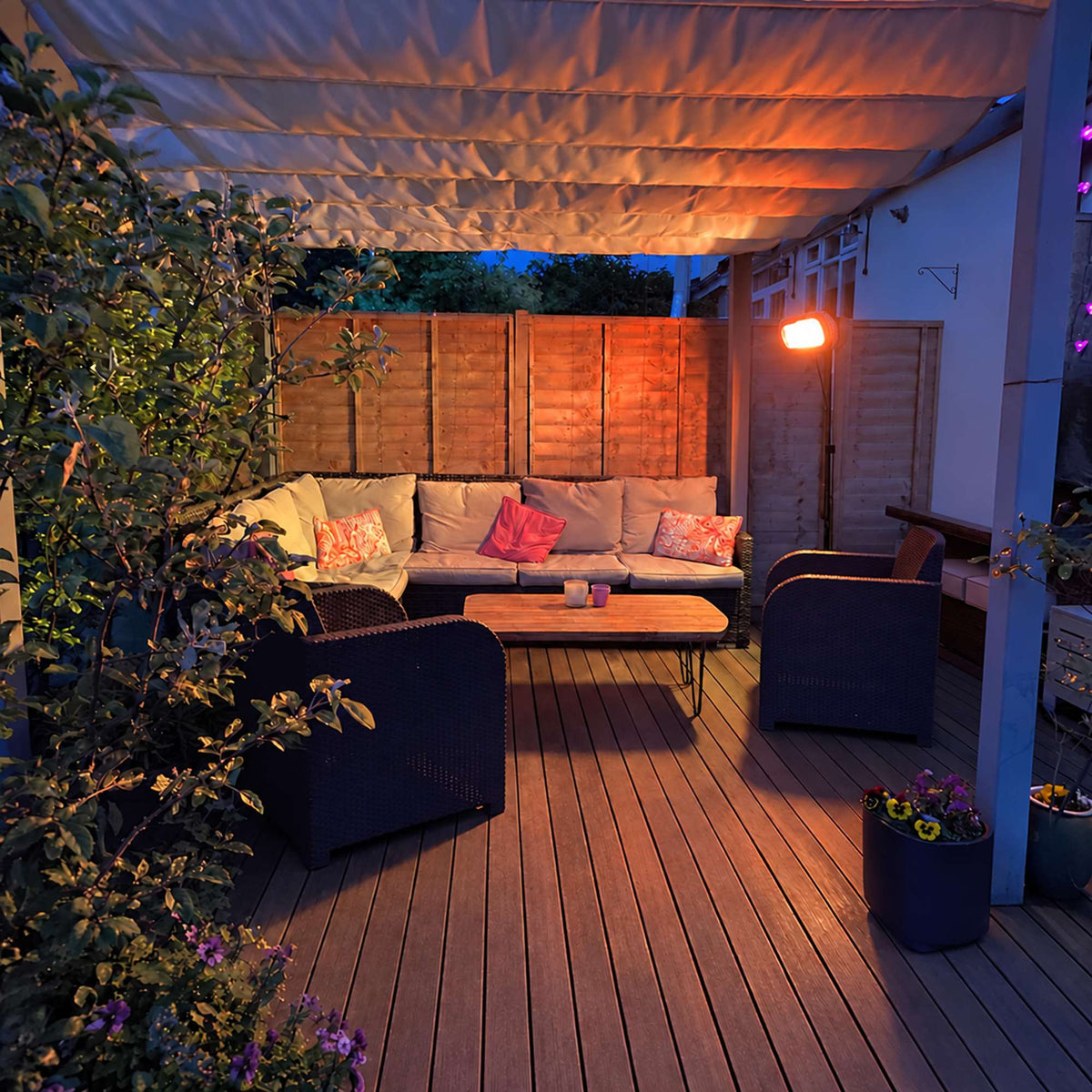 Witte Herschel MIAMI 2000 W infrarood terrasverwarmer op zwarte standaard bij een overdekt terras in de avond
