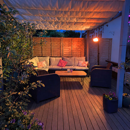 Witte Herschel MIAMI 2000 W infrarood terrasverwarmer op zwarte standaard bij een overdekt terras in de avond
