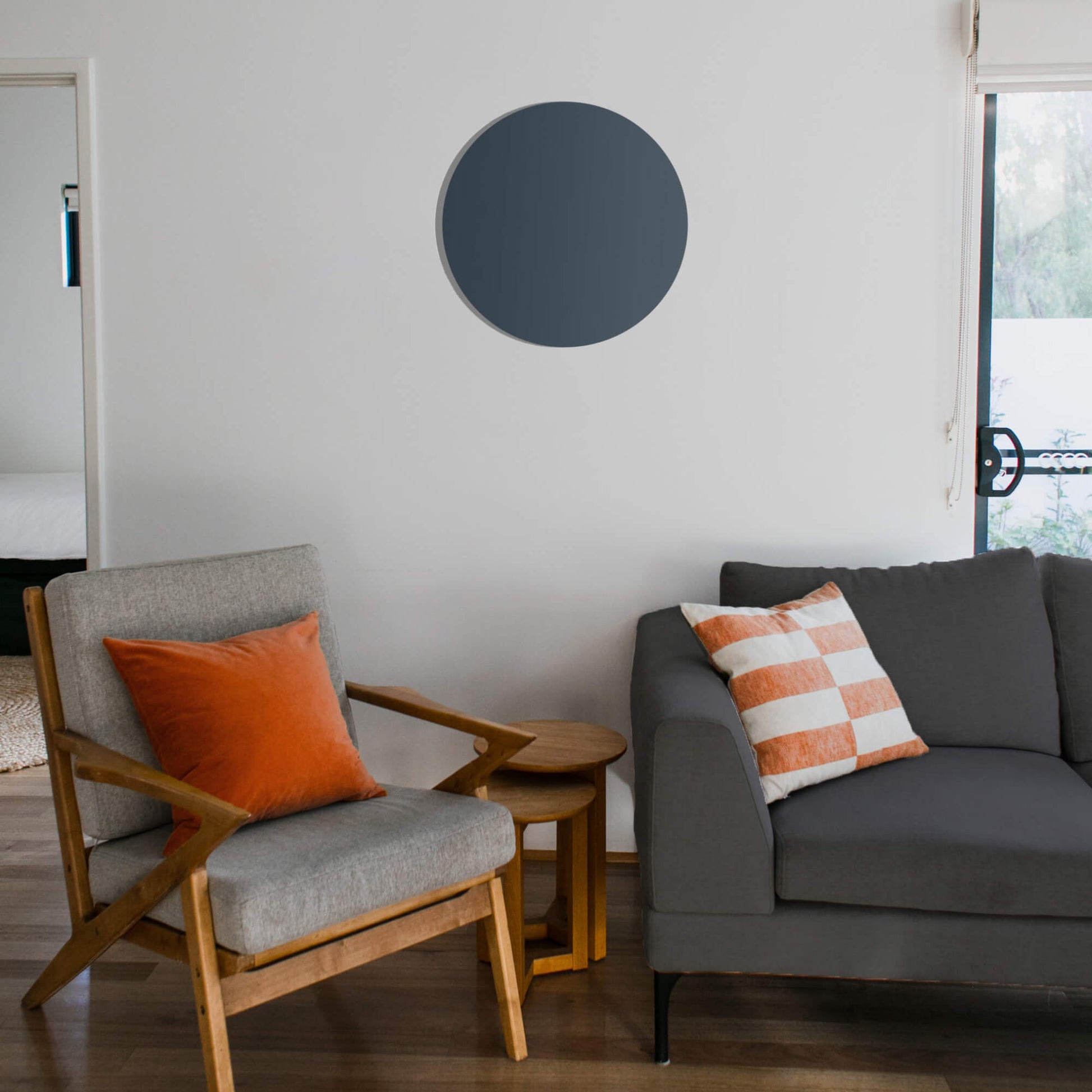 Rond grijs Herschel Select XLS infraroodpaneel op witte muur in een woonkamer