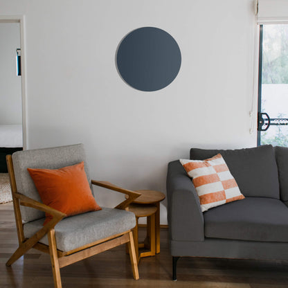 Rond grijs Herschel Select XLS infraroodpaneel op witte muur in een woonkamer