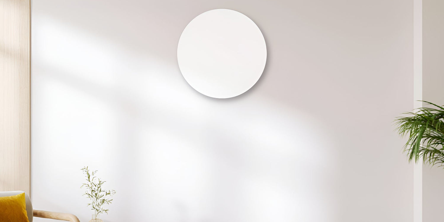 Rond wit infraroodpaneel tegen een lichte muur in een modern interieur