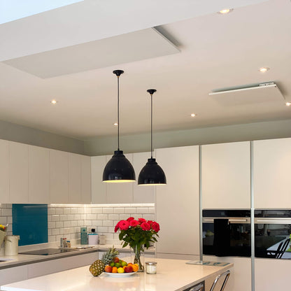 2 witte infraroodpanelen aan plafond in moderne keuken met kookeiland en verlichting