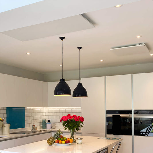 2 witte infraroodpanelen aan plafond in moderne keuken met kookeiland en verlichting