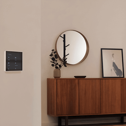 slimme wandthermostaat gemonteerd aan de muur in een woonkamer boven een houten kast
